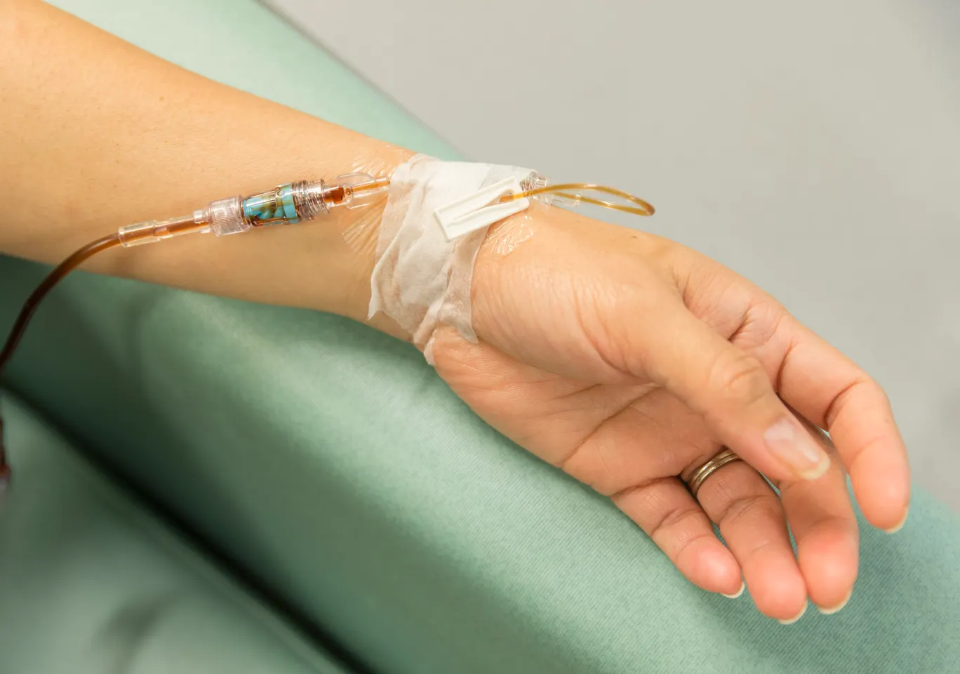 Kroplówki witaminowe Ząbkowice Śląskie: dłoń z wenflonem i linią infuzyjną na podkładzie